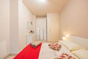 a bedroom with a large bed with a red blanket at Teeny House in Fossano