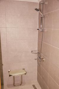 a bathroom with a shower with a bench in it at Anemon Uşak Hotel in Uşak