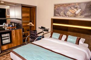 - une chambre avec un lit et un fauteuil roulant dans l'établissement Anemon Uşak Hotel, à Uşak