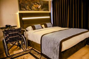 een slaapkamer met een bed met een kar ernaast bij Anemon Uşak Hotel in Usak
