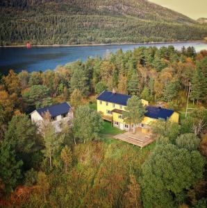 una vista aérea de una casa en una colina junto a un lago en Unique totally private island in a Norwegian fjord with space for 40 people, a dinner room and a chapel, en Simle