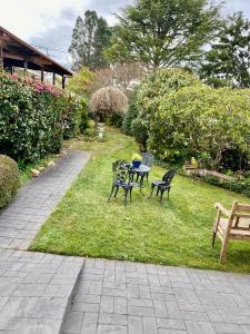 two chairs and a table in the grass with at French Provincial The Garden Suite at Chapmans with Breakfast & Pets in Moss Vale