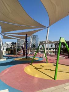 an empty playground with swings and a play equipment at Shared Ensuite BURJ Khalifa VIEW King Bedroom in 2Bed near Dubai Mall 8mins away in Dubai