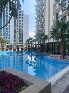 una gran piscina con palmeras y edificios en Shared Ensuite BURJ Khalifa VIEW King Bedroom in 2Bed near Dubai Mall 8mins away en Dubái