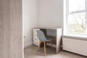 a desk and a chair in a room with a window at Lovely 2-Bedroom Conveniently Close to Bury & Manchester in Stubbins