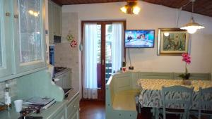 a kitchen with a table with chairs and a television at campiglio; dedica a te la calda mansarda di pia in Madonna di Campiglio