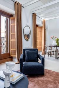 a living room with a chair and a table at San Bernardo - Darya Living in Madrid