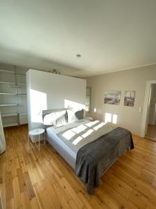 a bedroom with a large bed and a wooden floor at Apartmenthaus Thommen in Nürnberg