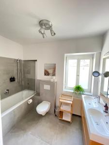 La salle de bains est pourvue de toilettes, d'une baignoire et d'un lavabo. dans l'établissement Apartmenthaus Thommen, à Nuremberg