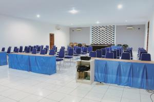 a room with blue chairs and tables with blue table cloth at Hotel Olympic Jogyakarta by Sajiwa in Yogyakarta