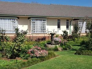 a house with a garden with a fountain in the yard at 40 on Ilkey B&B in Pretoria