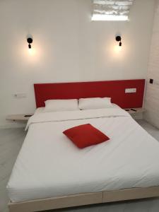 リヴィウにあるRed & Yellow Old Townのベッドルーム(赤いヘッドボード付きの白い大型ベッド1台付)