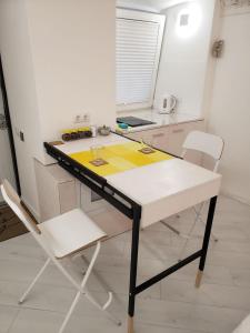 a kitchen with a table and two chairs at Red & Yellow Old Town in Lviv