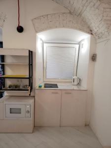 a small white kitchen with a window and a sink at Red & Yellow Old Town in Lviv