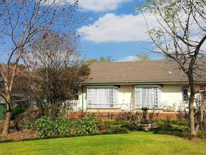 a white house with a yard with a house at 40 on Ilkey B&B in Pretoria