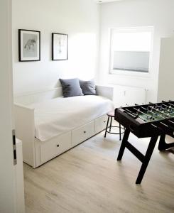 a white bedroom with a bed and a chess board at Ferienwohnung Lasse in Glücksburg