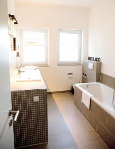 a bathroom with a tub and a sink at Ferienwohnung Lasse in Glücksburg