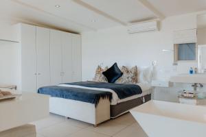 a white bedroom with a bed and a sink at Djis Tjil in Paternoster +39 photos