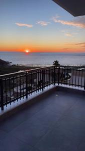 einen Balkon mit Blick auf das Meer bei Sonnenuntergang in der Unterkunft Ferienwohnung Meerblick in Gazipasa