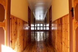 an empty hallway in an old building with wooden floors at Hotel Waterfall in Phakding