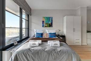 a bedroom with a large bed with three pillows at Downtown Apartments DOKI Living & Foodhall in Gdańsk