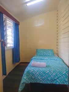 a bedroom with a bed with a pillow and a window at Shalom Mission Home in Mount Hagen