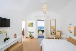 um quarto branco com uma cama e uma sala de estar em Villa Gianlica em Praiano