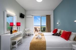 A bed or beds in a room at Bayside Hotel Katsaras