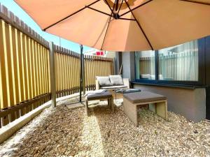 a patio with a chair and a table and an umbrella at Amazing large 2,5rooms with terrace and parking! in Bratislava