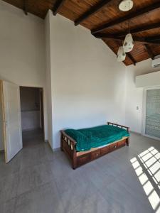 a bedroom with a green bed in a room at Casa Muka in Tandil
