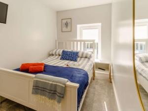 - une petite chambre avec un lit et un miroir dans l'établissement 3 Bed in Porthcawl 85193, à Newton