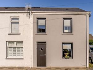 une maison blanche avec une porte et des fenêtres dans l'établissement 3 Bed in Porthcawl 85193, à Newton