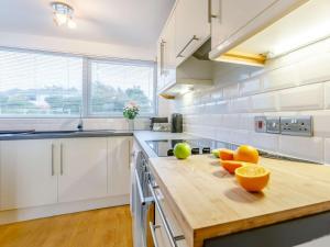 a kitchen with white cabinets and a wooden counter top at 2 Bed in Widemouth Bay 86152 in Marhamchurch