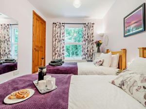um quarto com duas camas e uma mesa com uma bandeja de comida em 2 Bed in Ashbourne 85571 em Ashbourne