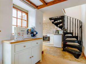 une cuisine avec un escalier en colimaçon dans une maison dans l'établissement 2 Bed in Ashford In The Water 85823, à Ashford