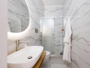 a bathroom with a sink and a toilet and a mirror at La Corte di Greta in Favignana +7 photos