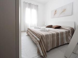 a white bedroom with a bed with two pillows on it at La Corte di Greta in Favignana