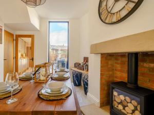 a dining room with a table and a clock on the wall at 3 Bed House With Hot Tub Great Ayton - TOP Terrace in Great Ayton