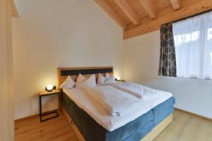 um quarto com uma cama grande e uma janela em Haus Margrith Alpenblick Appartements em Damüls