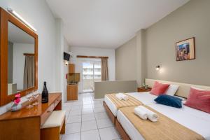 A bed or beds in a room at Bayside Hotel Katsaras