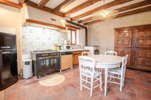 a kitchen with a table and a stove top oven at La Norandière - Superbe gîte à 15 min de Beauval ! in Beaumont-Village
