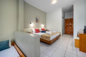 A bed or beds in a room at Bayside Hotel Katsaras