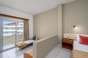 A bed or beds in a room at Bayside Hotel Katsaras