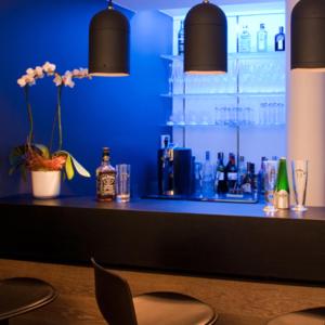 Hôtel Quatorze في كولمار: بار في غرفة زرقاء مع منضدة