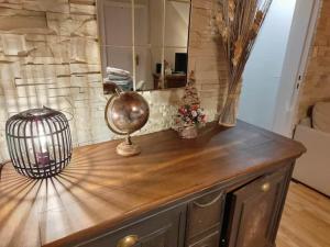 a wooden counter with a mirror and a bird cage on it at Le Nid - Appartement avec extérieur in Epfig