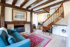 sala de estar con sofá azul y chimenea en La Poire en deux, en Reugny