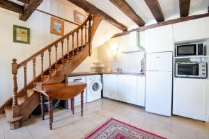 uma cozinha com electrodomésticos brancos e uma escadaria em La Poire en deux em Reugny