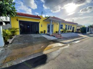ein gelbes Haus mit Garage auf einer Straße in der Unterkunft Near Casa Bacardi, 5 beds, Sleeps 10, Beach Town, Unit 1 in Catano