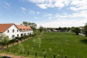 a large green field next to a white house at Het Zwinhuis - Spacious and comfortable family home near 't Zwin in Knokke-Heist
