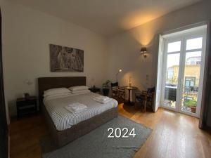 Un dormitorio con una cama y una ventana grande. en Vicolo dei Sartori, en Salerno